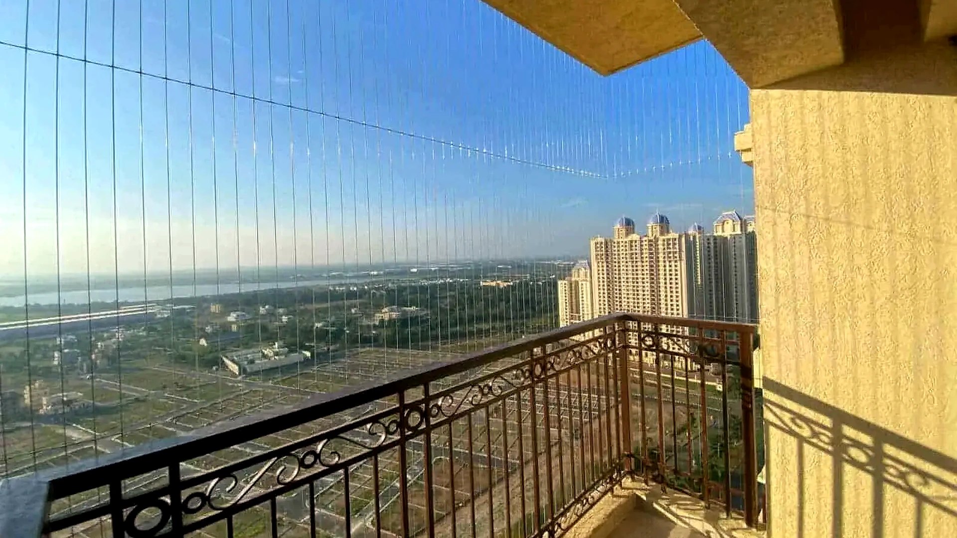 Balcony invisible grill installation on a high-rise apartment railing